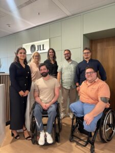 Vertreterinnen und Vertreter von JLL und dem Inklusionsfit Institut beim Auftaktgespräch zur strategischen Partnerschaft in Berlin (v. l. n. r.): Janina Bodrozic (Office Manager Berlin, JLL), Kristin Holz (Interim People Partner DACH & Arbeitssicherheitsausschuss, HR, JLL), Josephine Ulrich (Director EMEA Retail Leasing Strategy & Operations, JLL), Florian Malicke (Head of Product Workspace, Inklusionsfit Institut), Thomas Matic (Auditor & Experte für Sehbeeinträchtigungen, Inklusionsfit Institut), Nikola Arsic (Interior Workspace Design, Tétris Design & Build, JLL, sitzend) und Mirko Korder (Co-Founder & Geschäftsführer, Inklusionsfit Institut, sitzend).