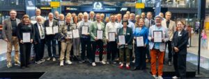 Gruppenfoto mit Auszeichnung: Die Preisträgerinnen und Preisträger des MOTORWORLD Buchpreises 2025 bei der feierlichen Verleihung in der MOTORWORLD München – darunter auch Roland Arnold von der PARAVAN GmbH (1. Reihe, 5. v. li.) mit dem Ehrenpreis Biografie. Foto: CanVanCan