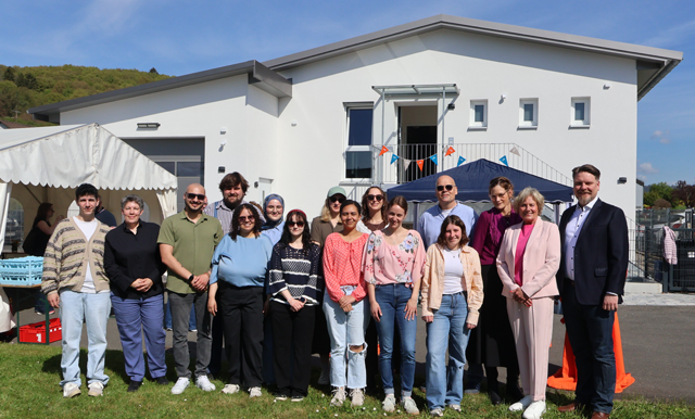 Bitte lächeln: Gruppenbild der stolzen Mitarbeitenden vor den neuen Räumlichkeiten.