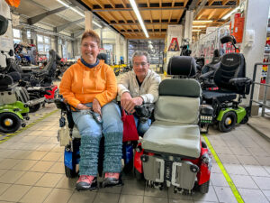 Ein treuer Begleiter über viele Jahre: Ulrike mit ihrem bisherigen Rollstuhl (links) und ihrem neuen Paravan PR 50 (rechts) – zusammen mit Stefan Ludwig, Leiter Rollstuhlsysteme. Foto: Paravan